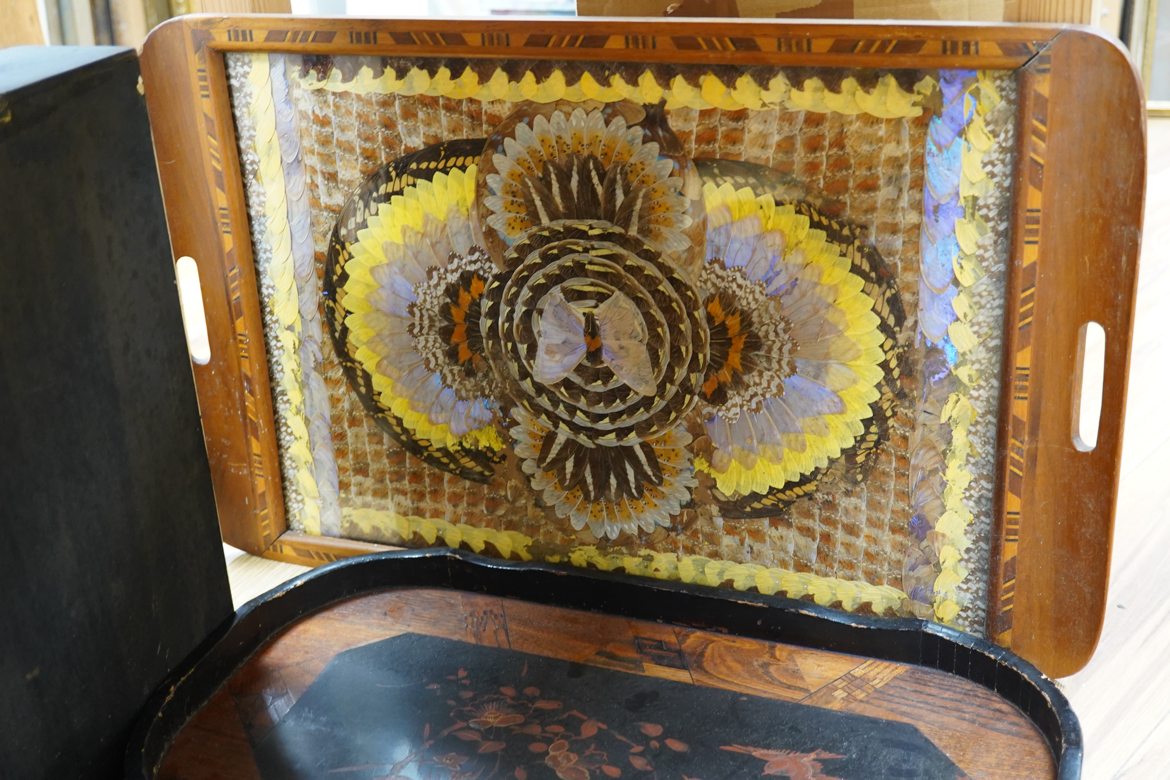 Three trays to include a butterfly wing example and a Japanese lacquered example decorated with birds and flowers, 75cm wide. Condition - poor to fair